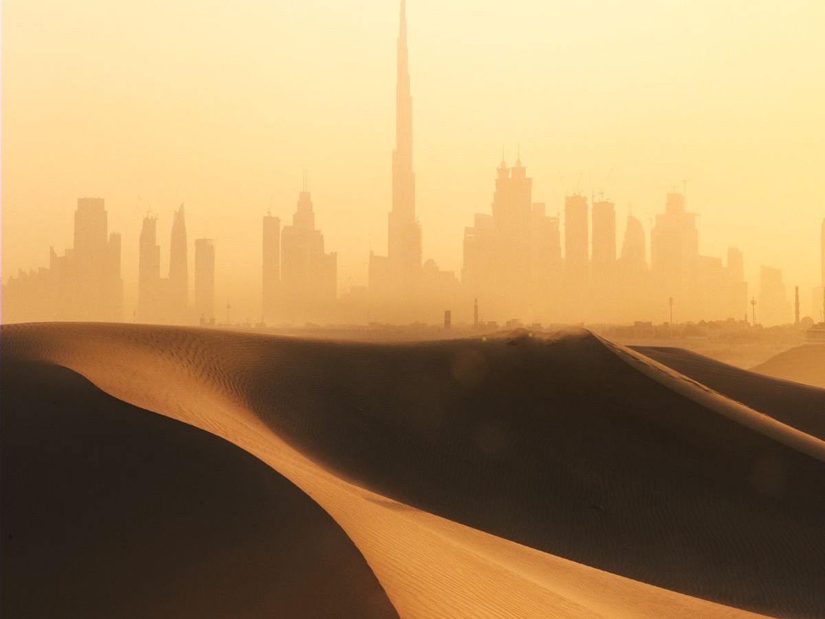 Dubai skyline behind desert dunes
